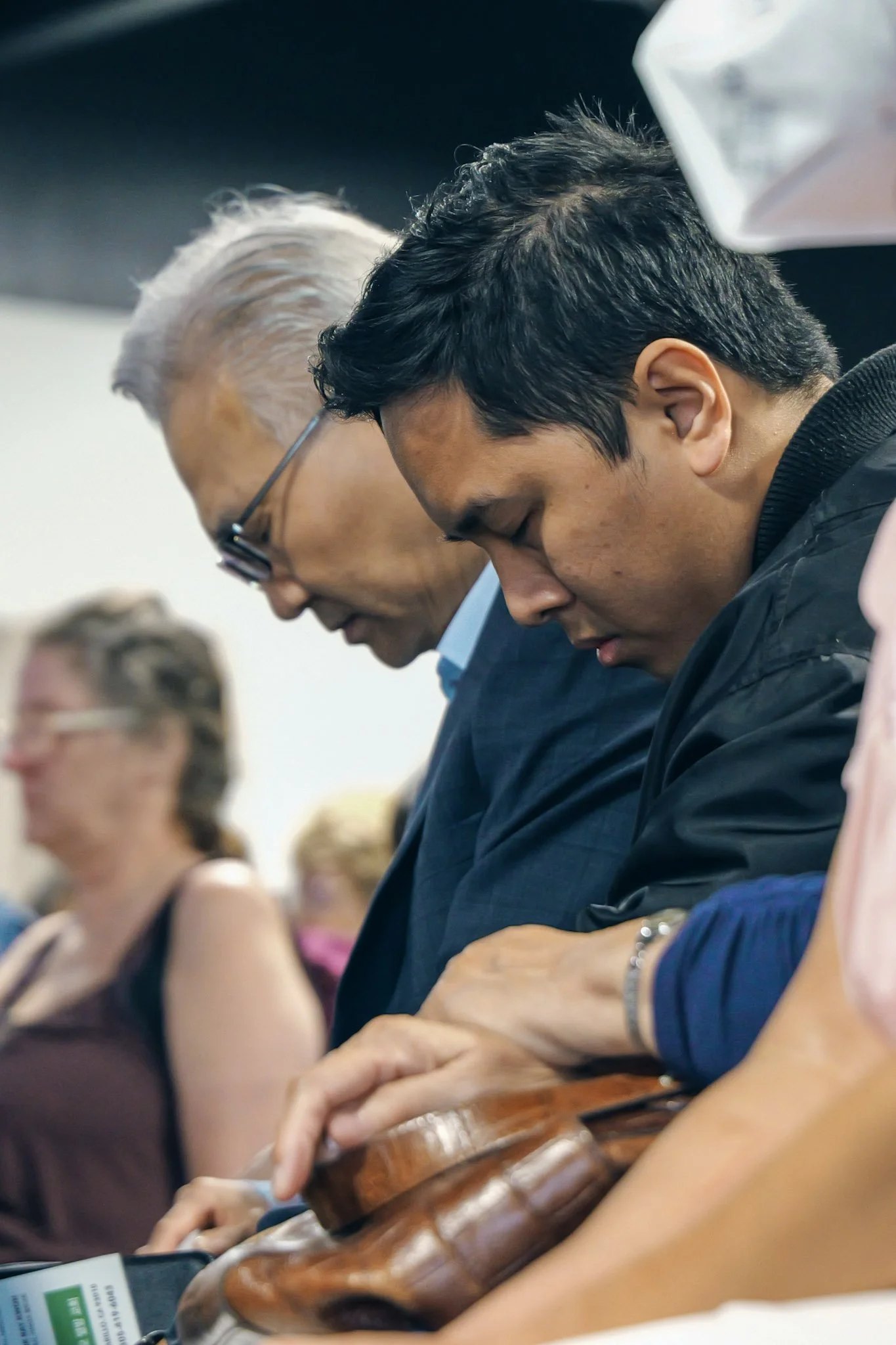 Members praying together, laying hands on one another